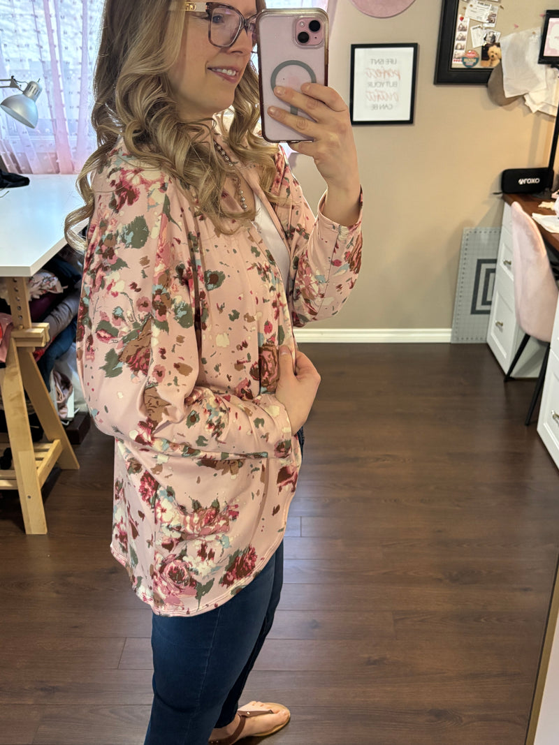 A soft, flowy dolman sleeve cardigan with a delicate floral pattern, draped over a model. The lightweight fabric gives it an airy, relaxed fit, making it a versatile layering piece. Designed to fit sizes 2 to 16, this cardigan features a flattering silhouette with an open front. Perfect for casual or dressy outfits, the breathable material ensures comfort in all seasons.